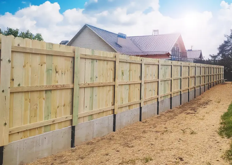 commercial wood fence mounted to wall 6' Solid Board Fence Mounted to Concrete Wall with Postmaster Plus Posts